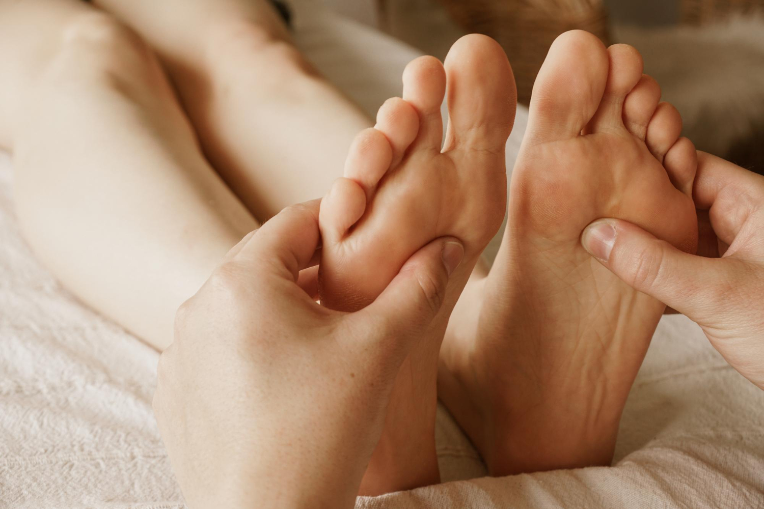 Close-up of a person receiving a foot massage, emphasizing the soles of both feet. This image represents diabetic foot care, which is essential for preventing rashes, infections, and complications.
